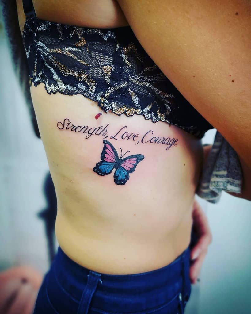 Tattoo of the words "Strength, Love, Courage" above a butterfly on a person's side