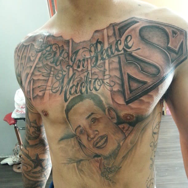 Detailed chest memorial tattoo featuring the words "Rest In Peace Macho" and a portrait of a man