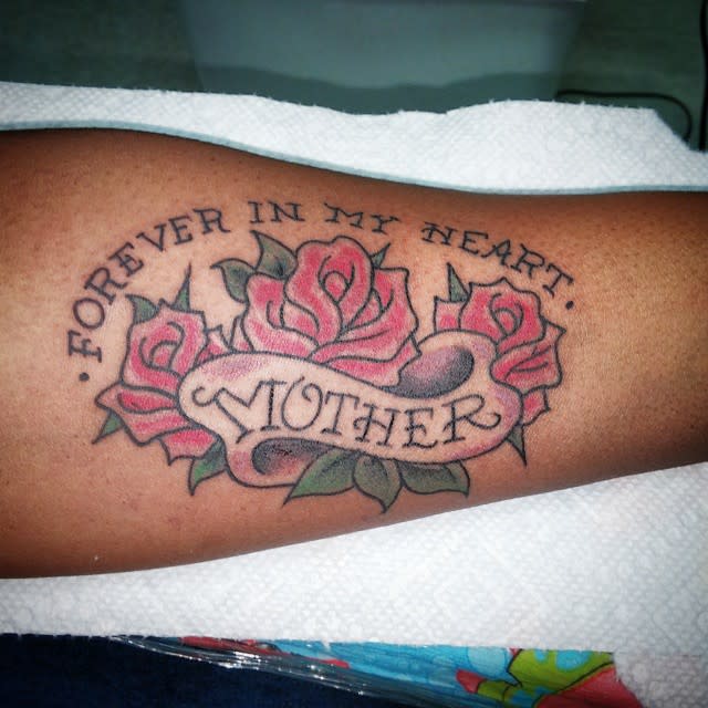 Memorial tattoo with "Forever in my heart, Mother" text and roses on an arm
