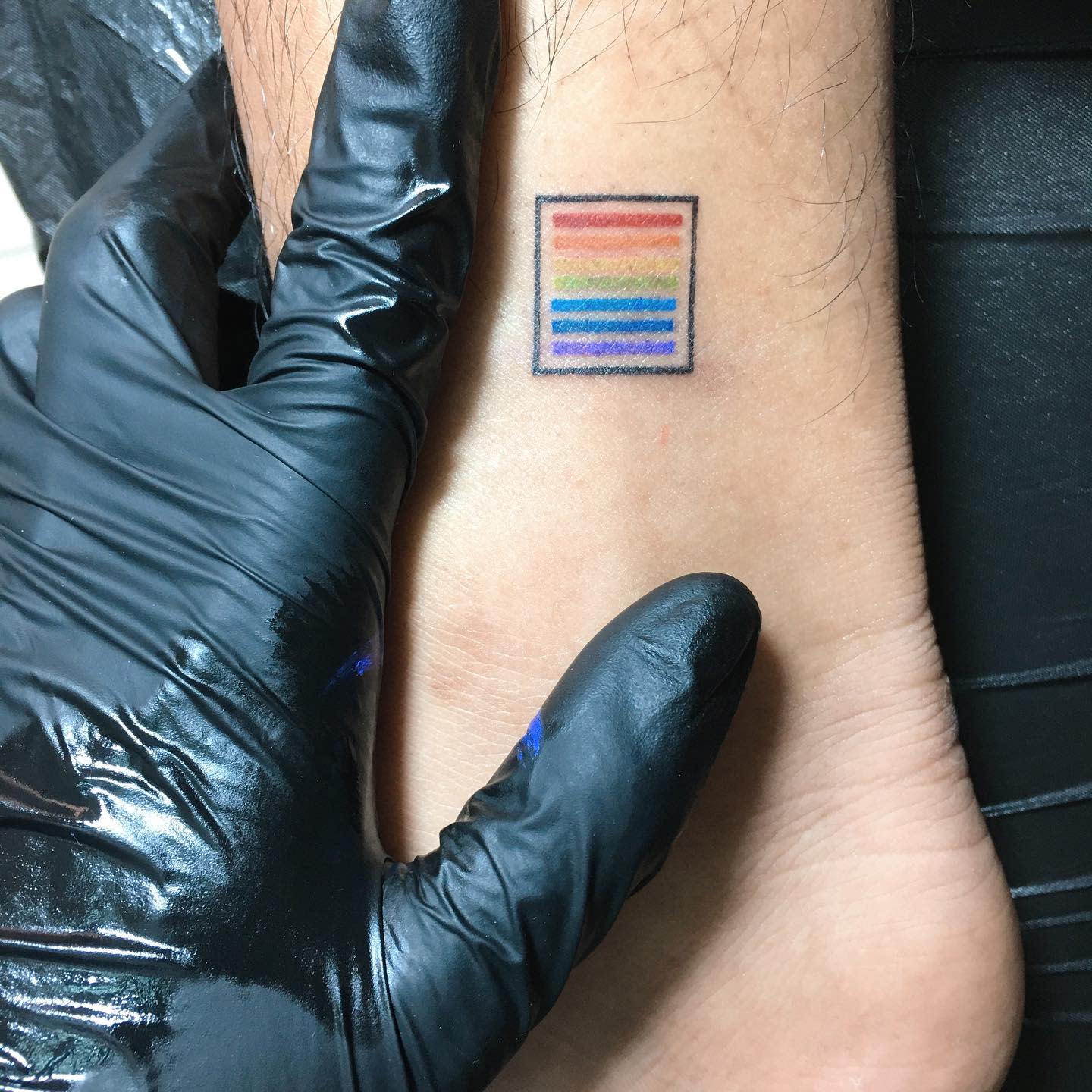 Ankle with rainbow striped tattoo