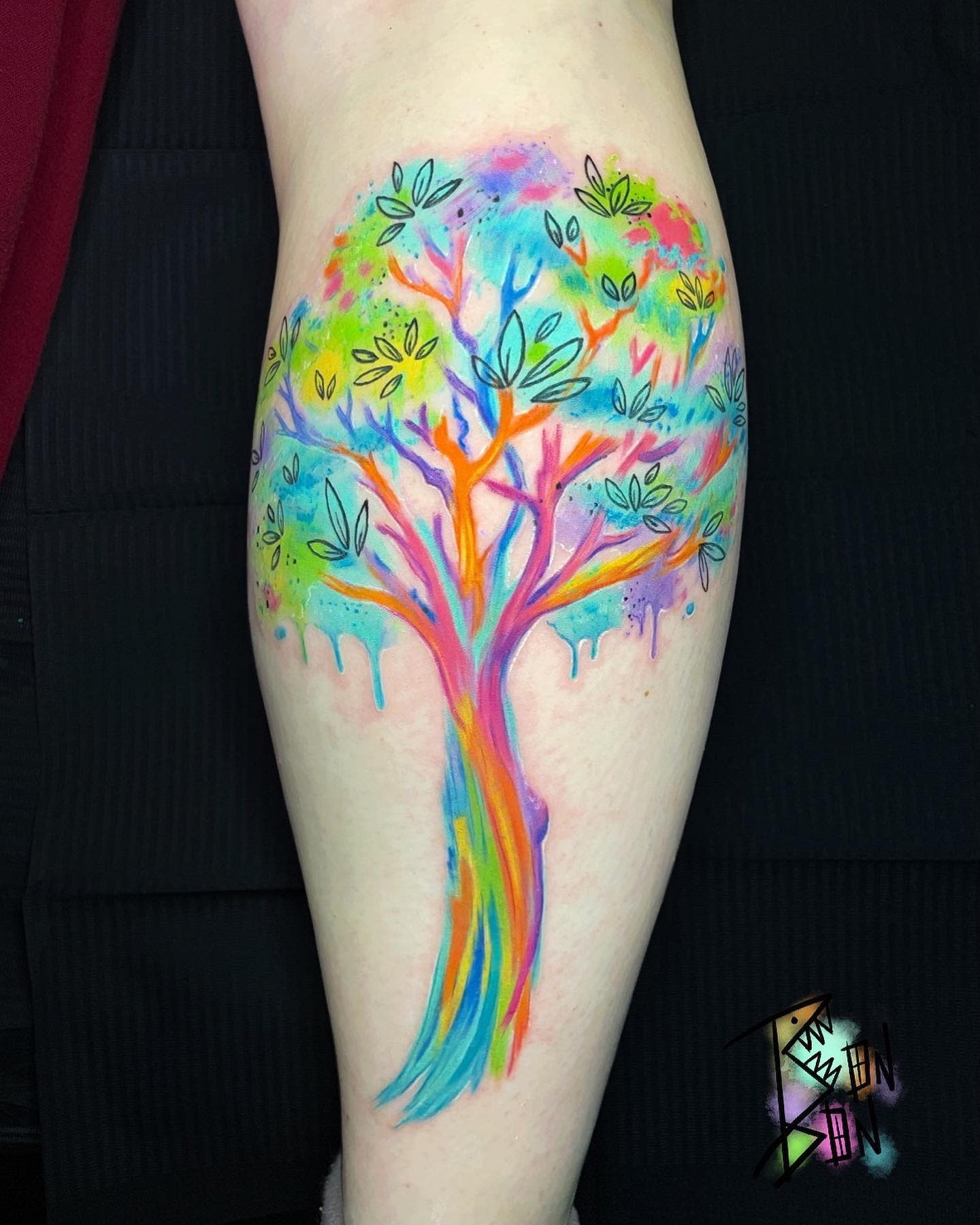 Colorful tree tattoo with vibrant leaves and branches on an arm