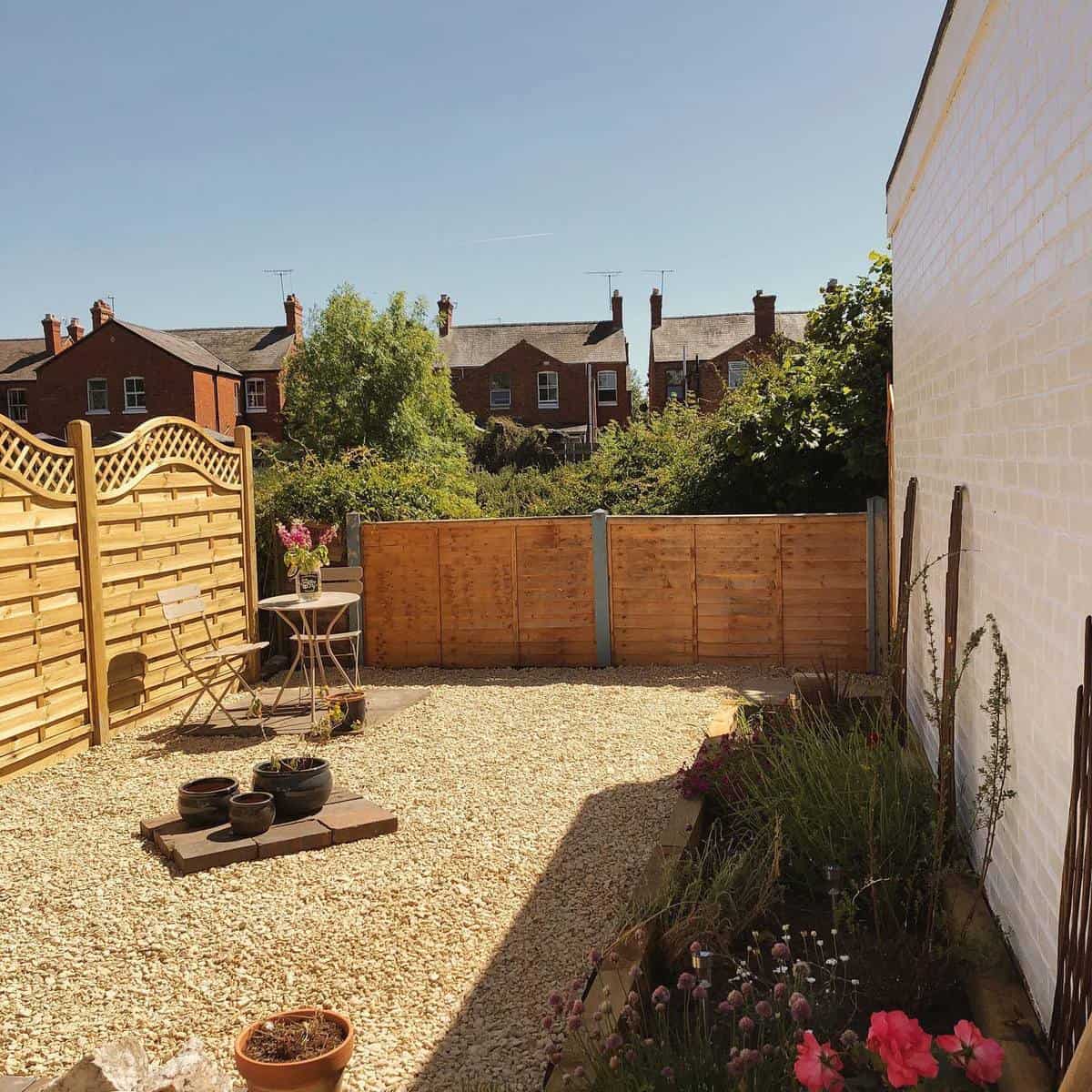 gravel garden wood fences table and chairs raised garden bed 