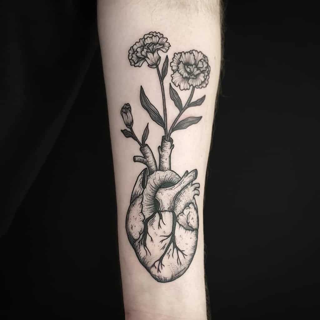 Black tattoo of a realistic human heart, with blooming flowers growing from it