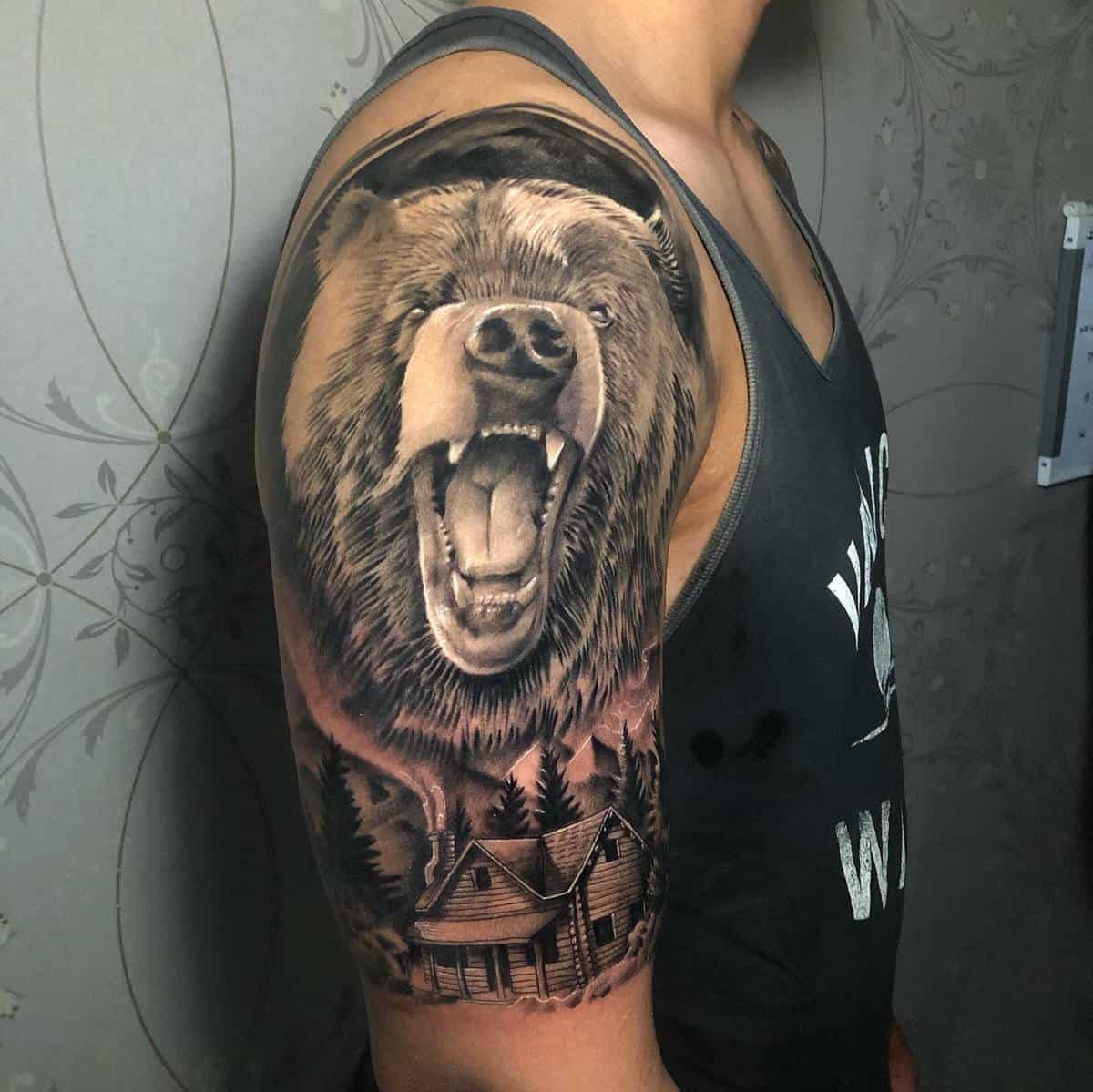 Bear tattoo on arm with cabin in woods scene