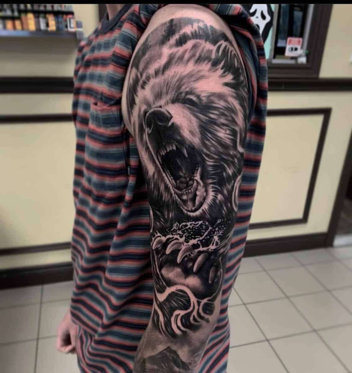 Tattoo of a roaring bear on a man's arm