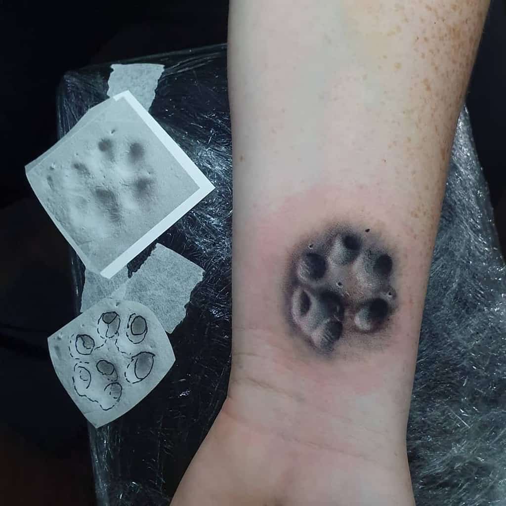 Tattoo of a realistic cat paw print on a wrist