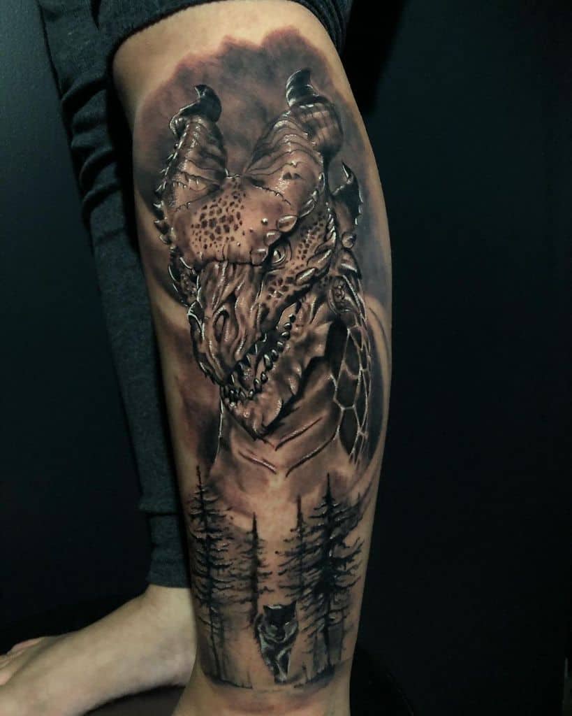 Realistic calf tattoo of a dragon's head with intricate details, inspired by Game of Thrones, set against a forest scene