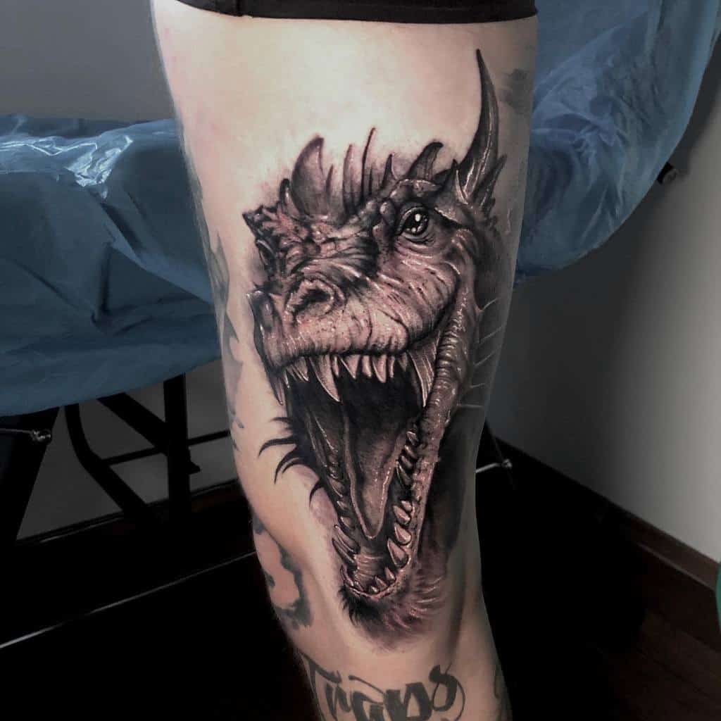 Tattoo of a roaring dragon on a person's leg