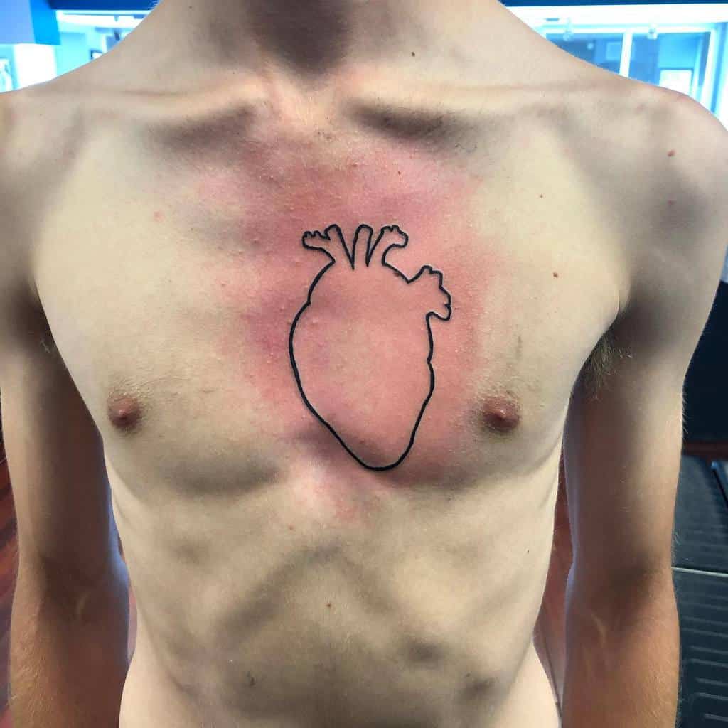 An outline tattoo of an anatomically correct heart centered on the chest