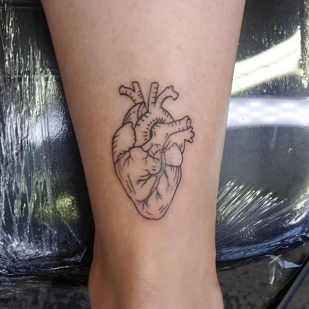 Tattoo of a human heart line art on a forearm