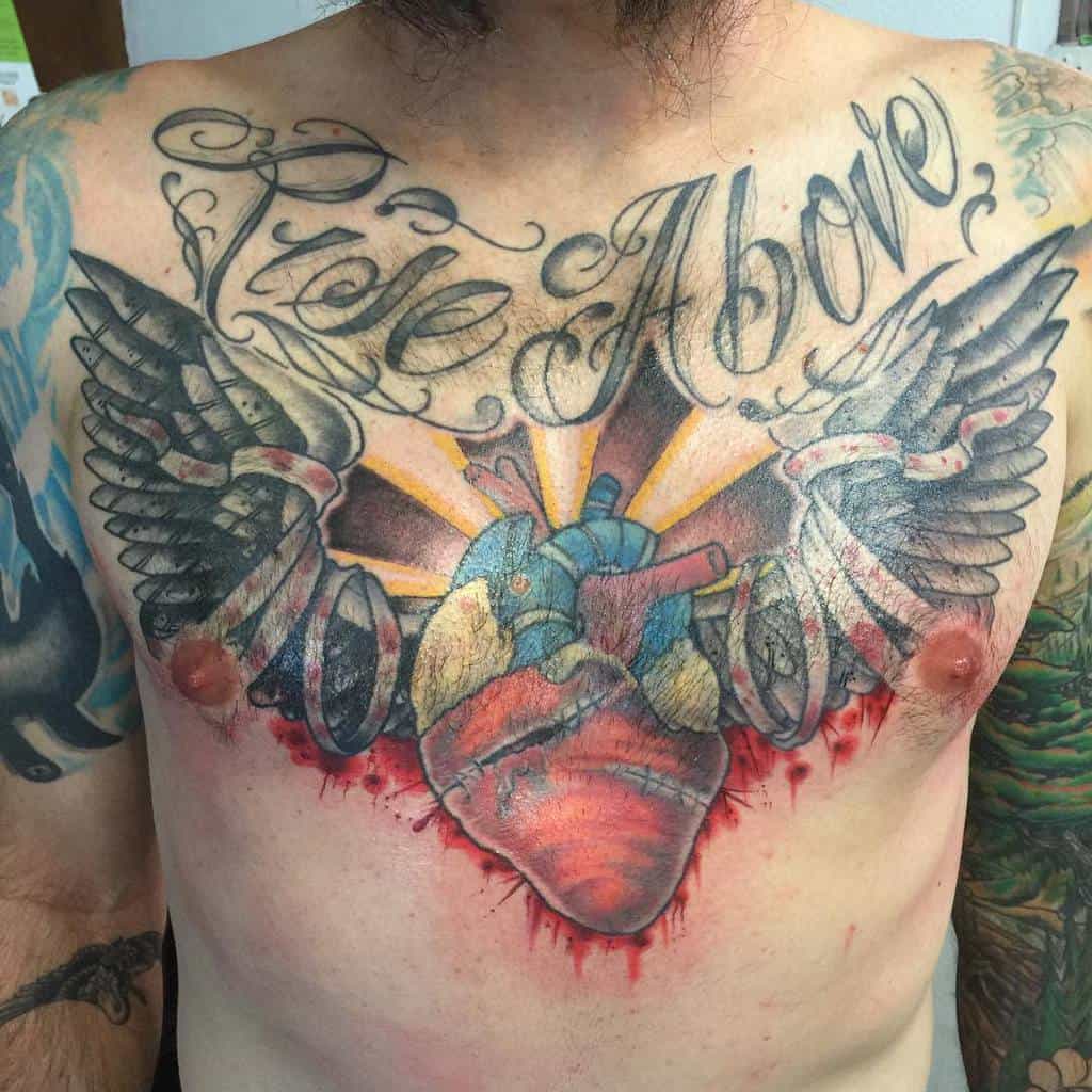 Colorful chest tattoo featuring a vibrant heart with wings, radiating light rays, and the inspiring text "Rise Above"