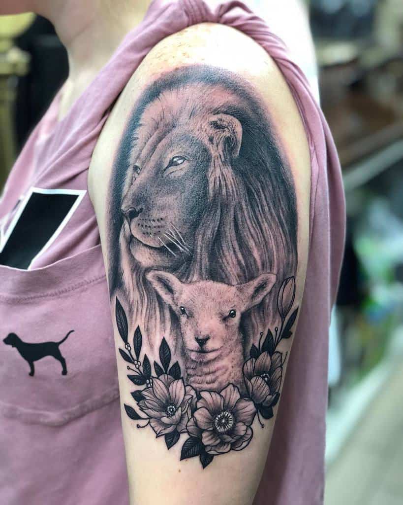 Tattoo of a lion and a lamb gracefully intertwined, surrounded by delicate flowers on a person's upper arm