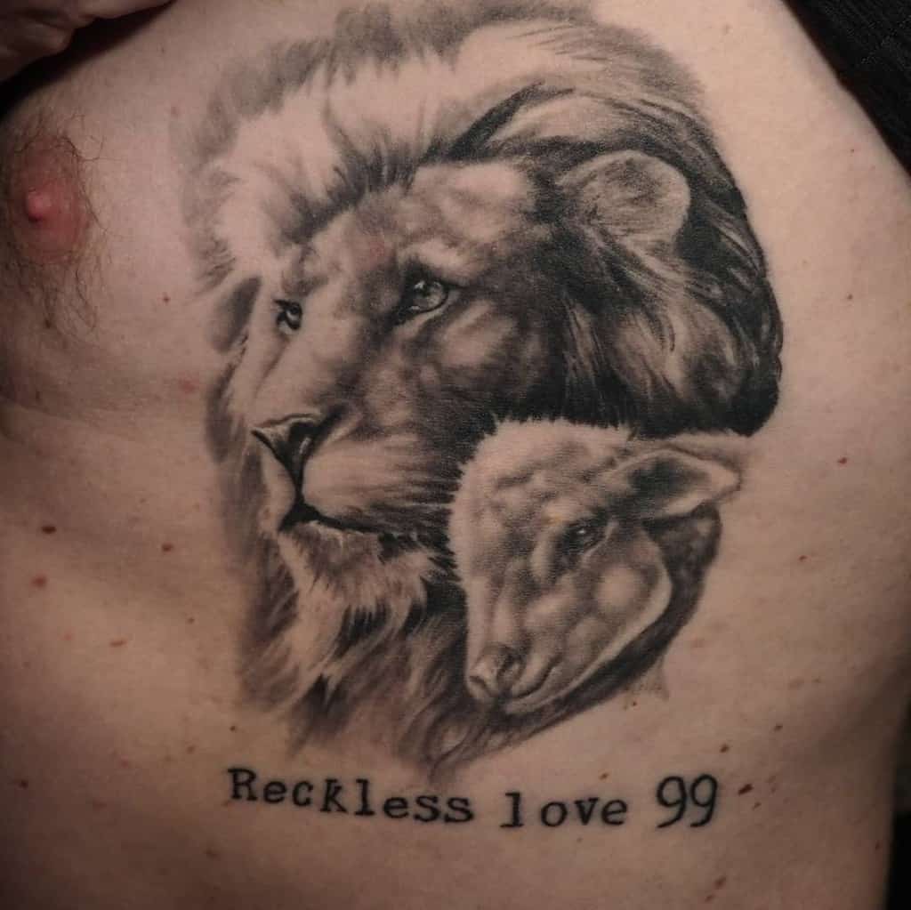 Tattoo of a lion embracing a lamb with "Reckless love 99" written beneath on a person's chest