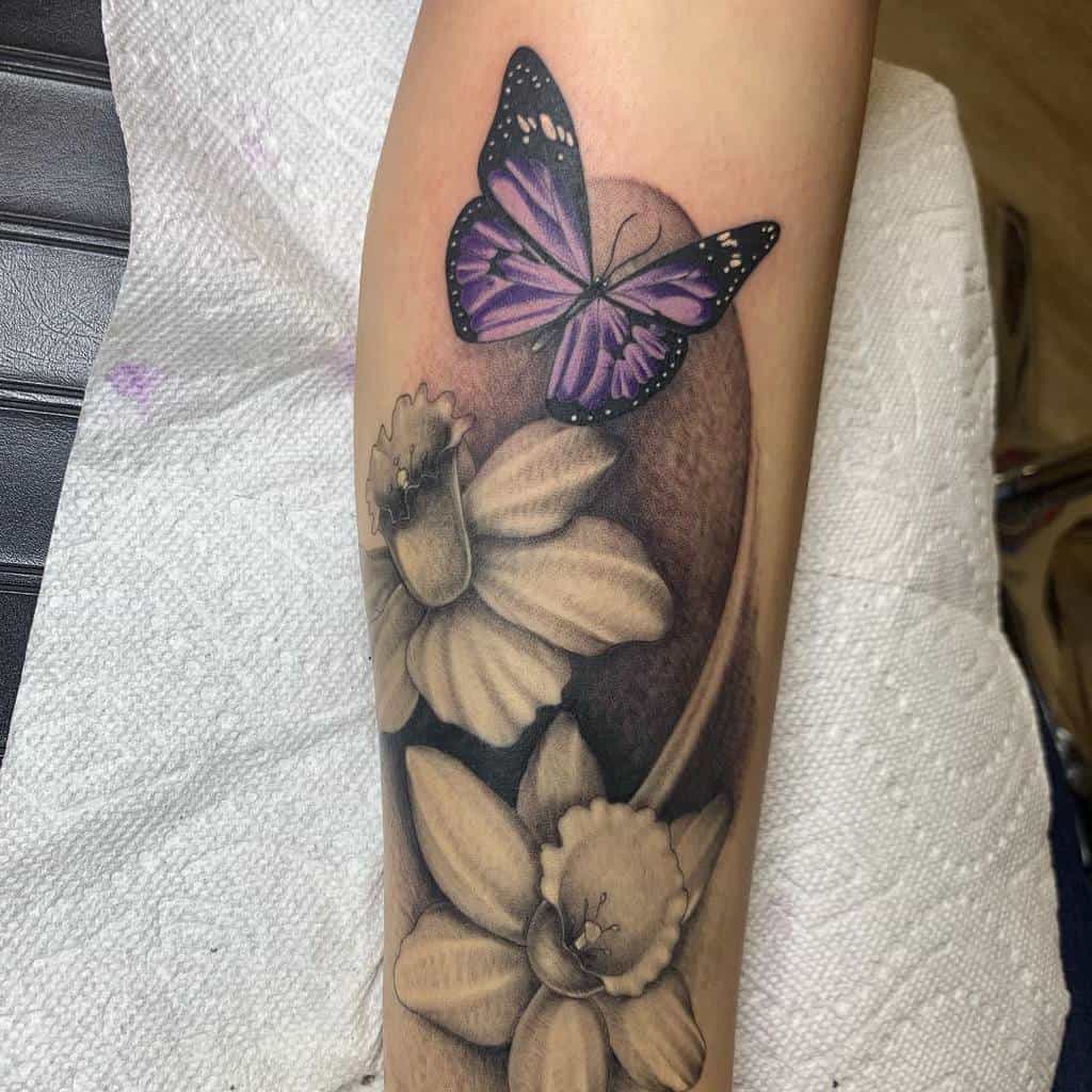 Tattoo of a purple butterfly and black-and-white daffodils on a forearm