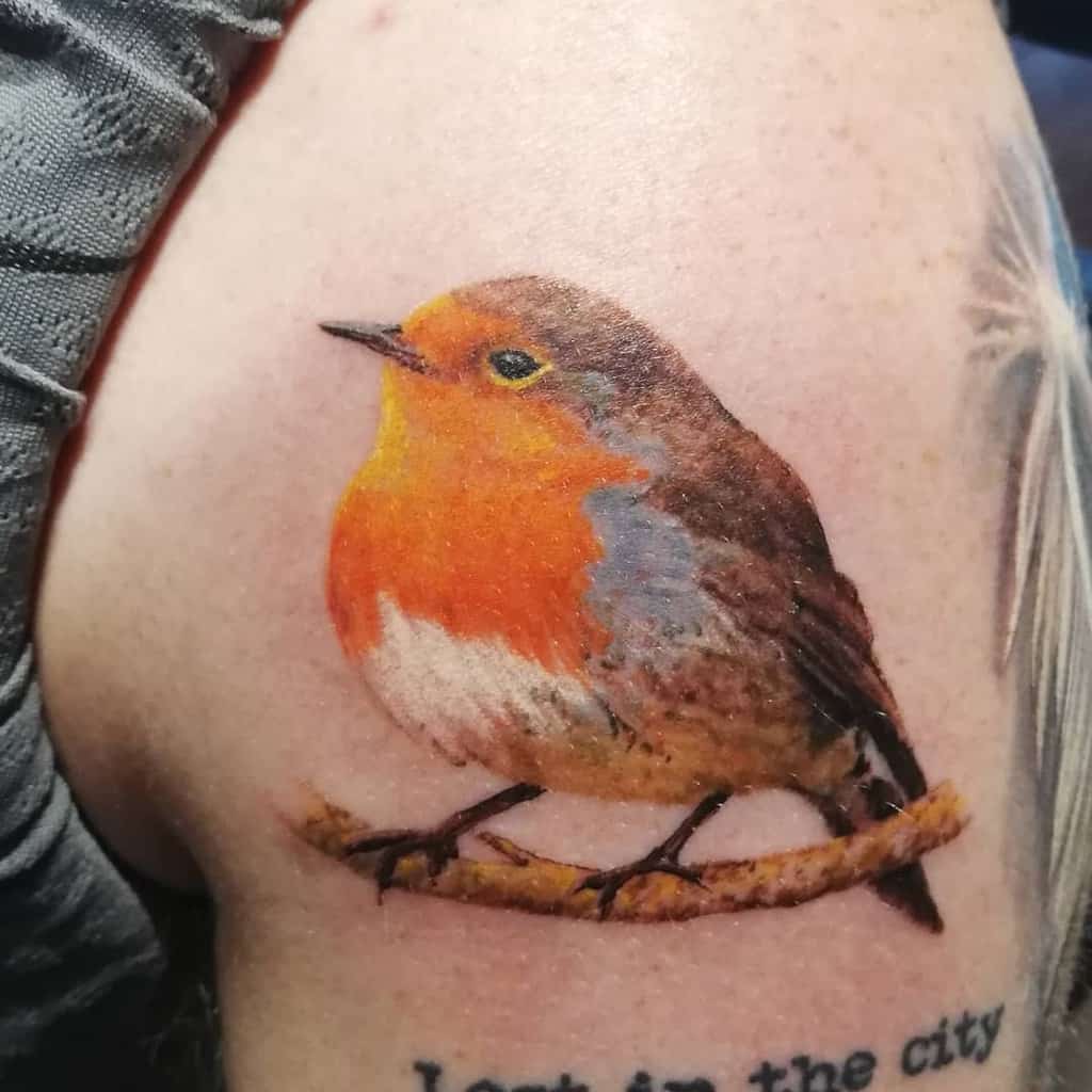 Colorful tattoo of realistic chubby robin perched on a branch