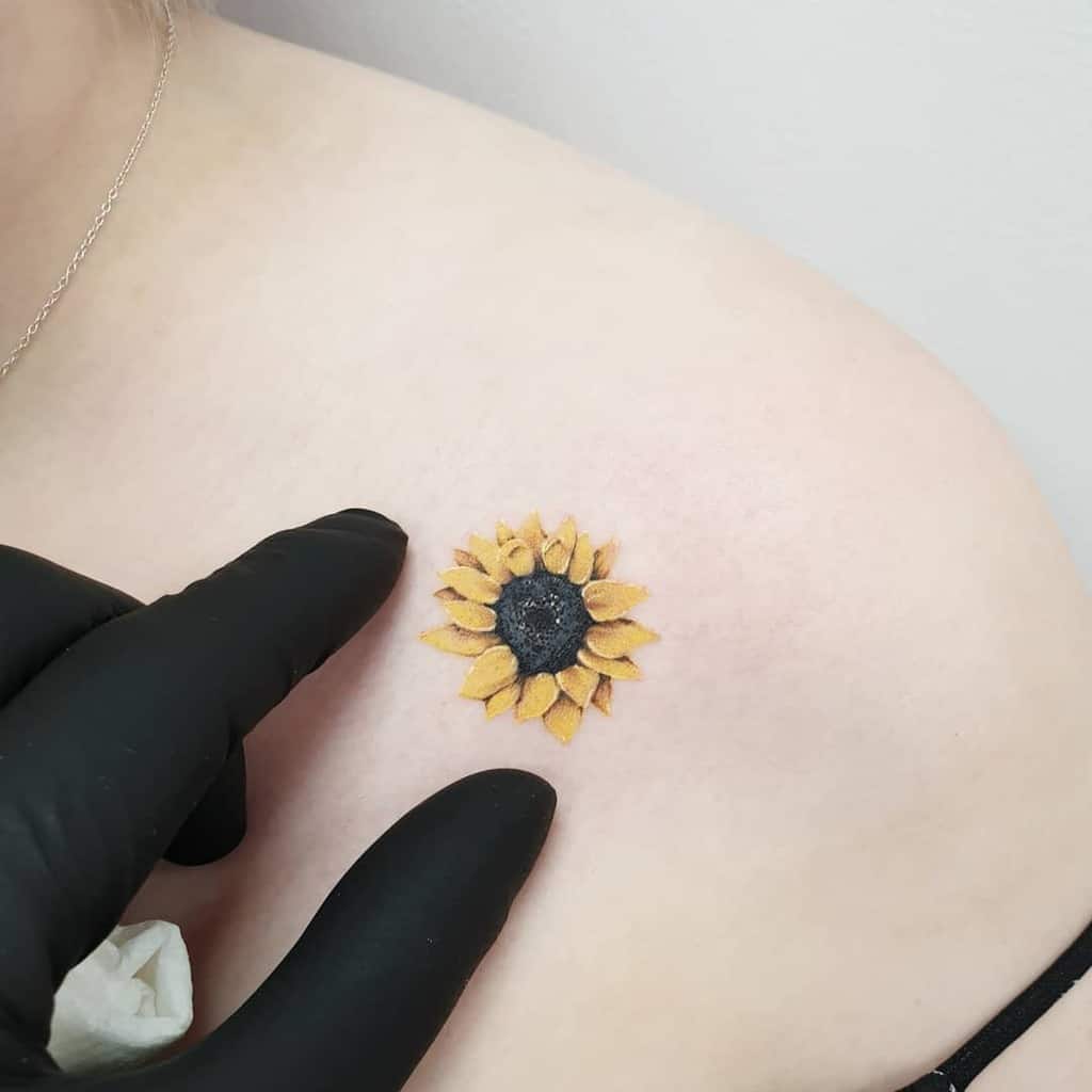 Small sunflower tattoo on a shoulder