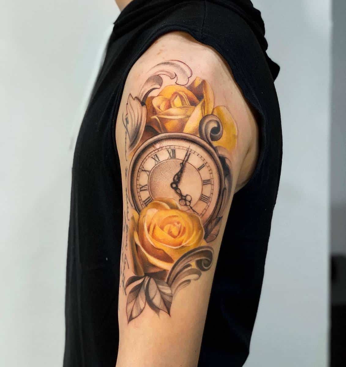 A tattoo of a pocket watch and yellow roses on an upper arm