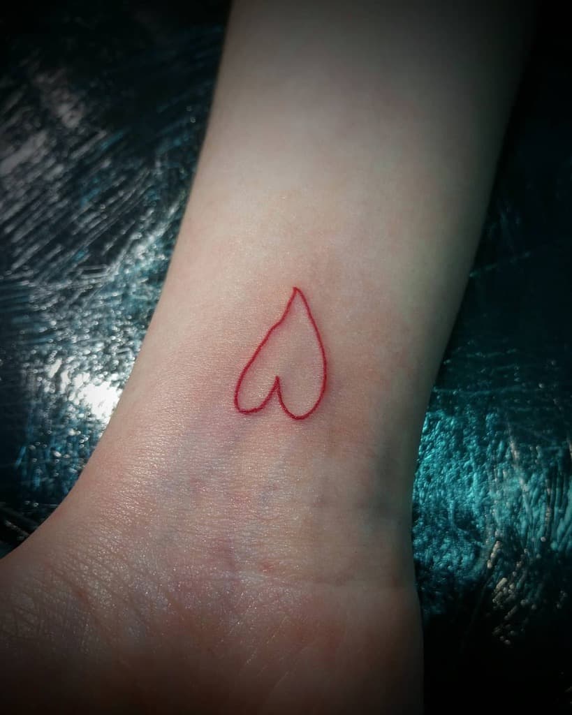 Outline of a heart-shaped tattoo on the inner wrist
