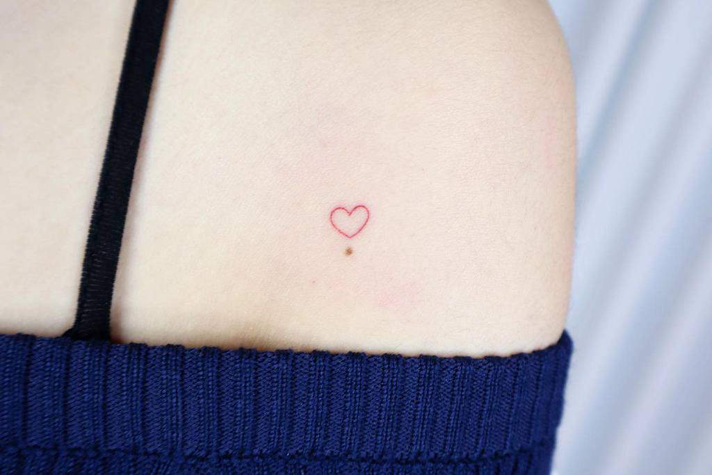 Simple red heart outline tattoo on a shoulder