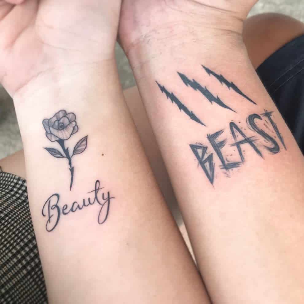 Two forearm tattoos: one with "Beauty" and a rose, the other with "Beast" and claw marks