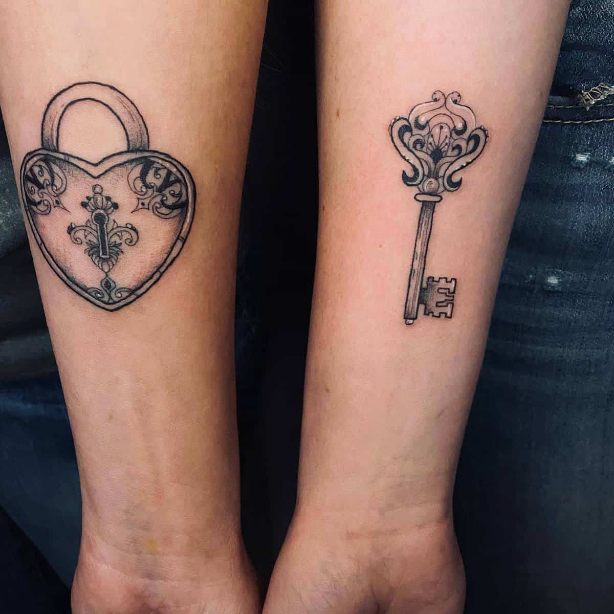 Two forearm tattoos: one of an intricate heart-shaped lock and one of a detailed key
