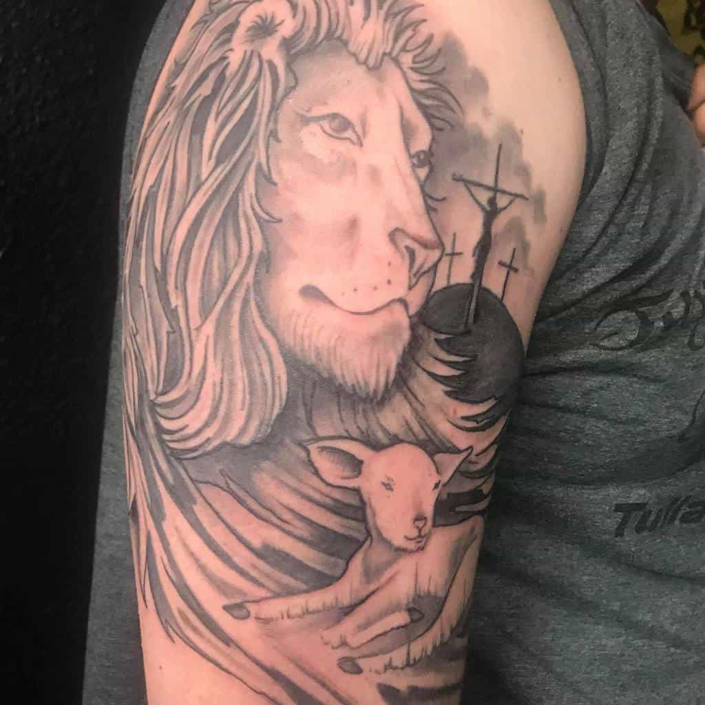 Tattoo of a majestic lion and gentle lamb with crosses in the background on a person's upper arm
