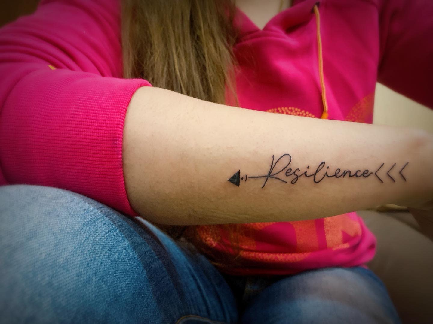 Cursive Resilience Tattoo with an Arrow
