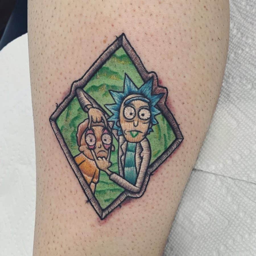 Embroidered fabric-effect tattoo of a chaotic cartoon duo, enclosed in a stitched diamond-shaped frame for a patch-like look.