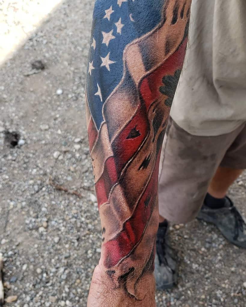 Arm tattoo of a waving American flag with vivid colors