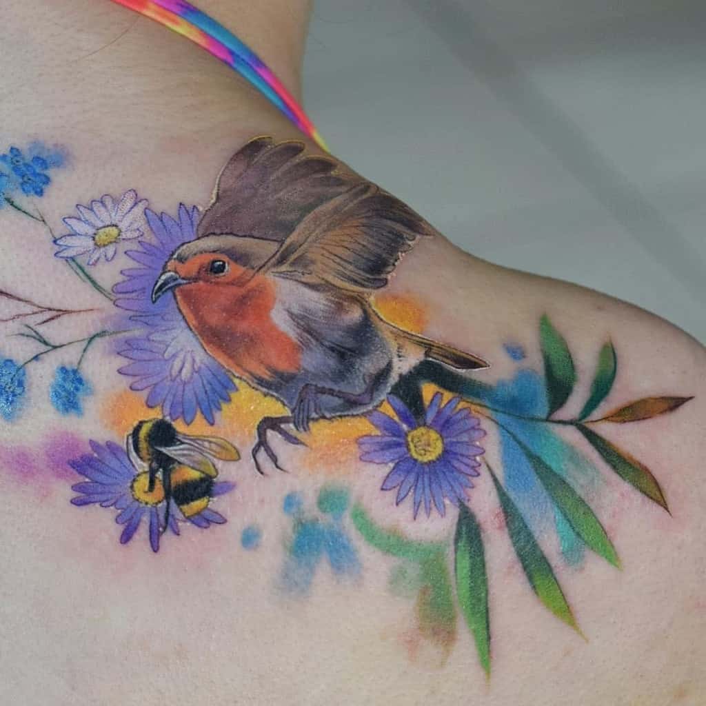 Colorful tattoo of a flying robin, bee, purple, white and blue flowers and leaves with abstract watercolor splashes