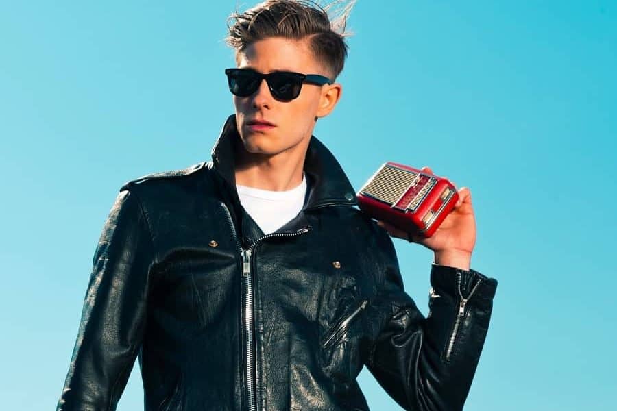 Man dressed in a rockabilly style wearing a leather jacket and sunglasses
