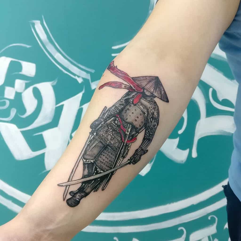 Elegant forearm tattoo of a Ronin in traditional armor, featuring a straw hat, red accents, and a katana for a minimalist yet striking design