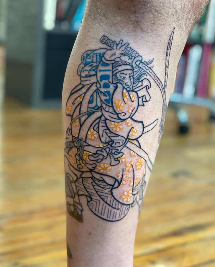 Detailed leg tattoo featuring a samurai in traditional Japanese attire with bold blue and orange floral patterns
