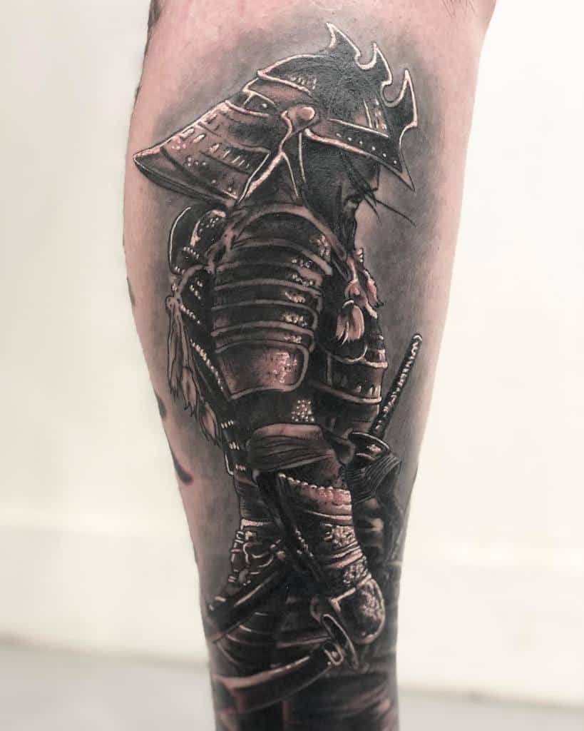 Realistic black and grey leg tattoo depicting a samurai warrior in traditional armor, viewed in profile, capturing intricate details of the helmet and body plates, symbolizing honor and strength