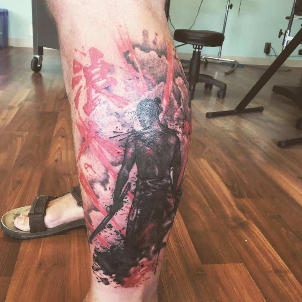 A bold samurai tattoo on the leg, featuring a warrior in action with dramatic red accents and a fluid, abstract background creating a dynamic and powerful look