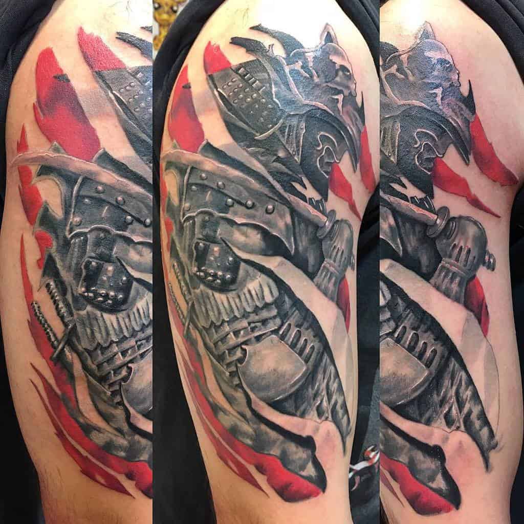 A bold samurai tattoo featuring intricate black-and-gray armor, with dynamic red flame accents that highlight the warrior’s powerful stance