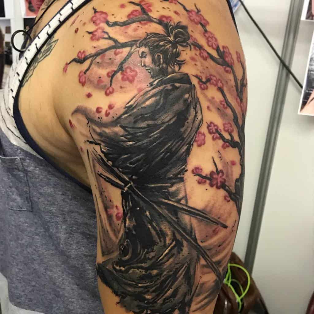 Samurai tattoo in black and gray with a warrior holding a katana, surrounded by delicate cherry blossoms, creating a serene yet powerful design