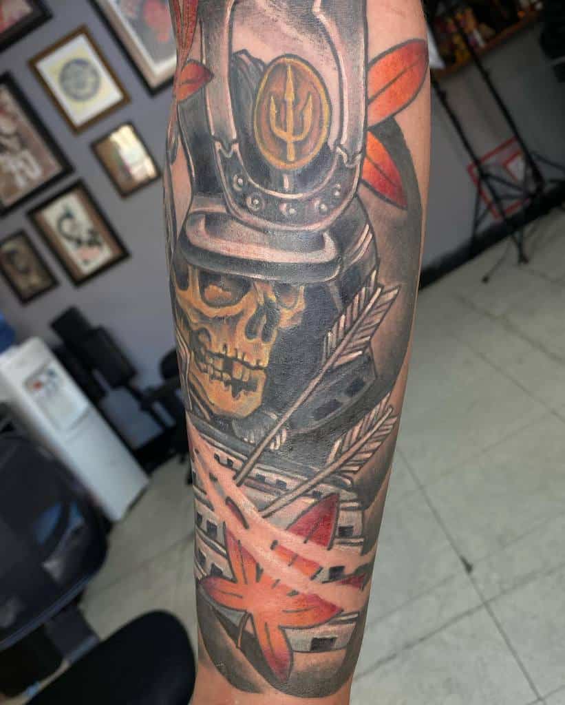Bold samurai skull tattoo with a striking helmet, crossed with arrows and adorned with red maple leaves, creating a fierce and dynamic design