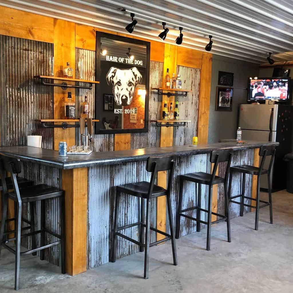Rustic basement bar with corrugated metal panels, wood accents, and industrial bar stools.
