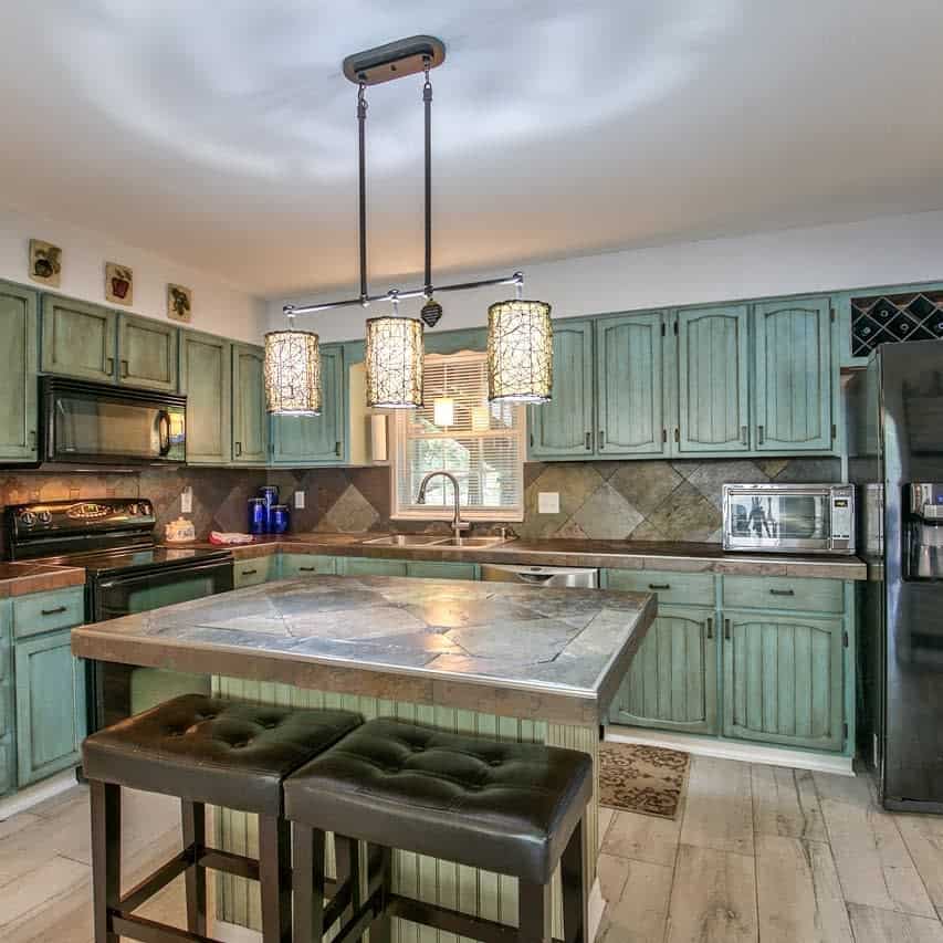 rustic corner kitchen green wood cabinets track pendant lighting small island two stools