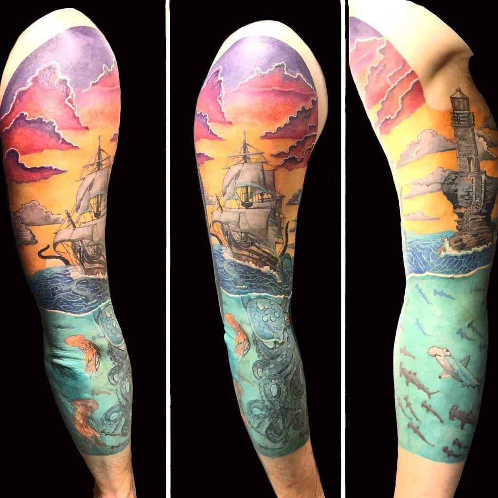 Tattoo featuring a ship, sunset, lighthouse, and ocean scene with a kraken and sharks in vibrant colors and detailed design
