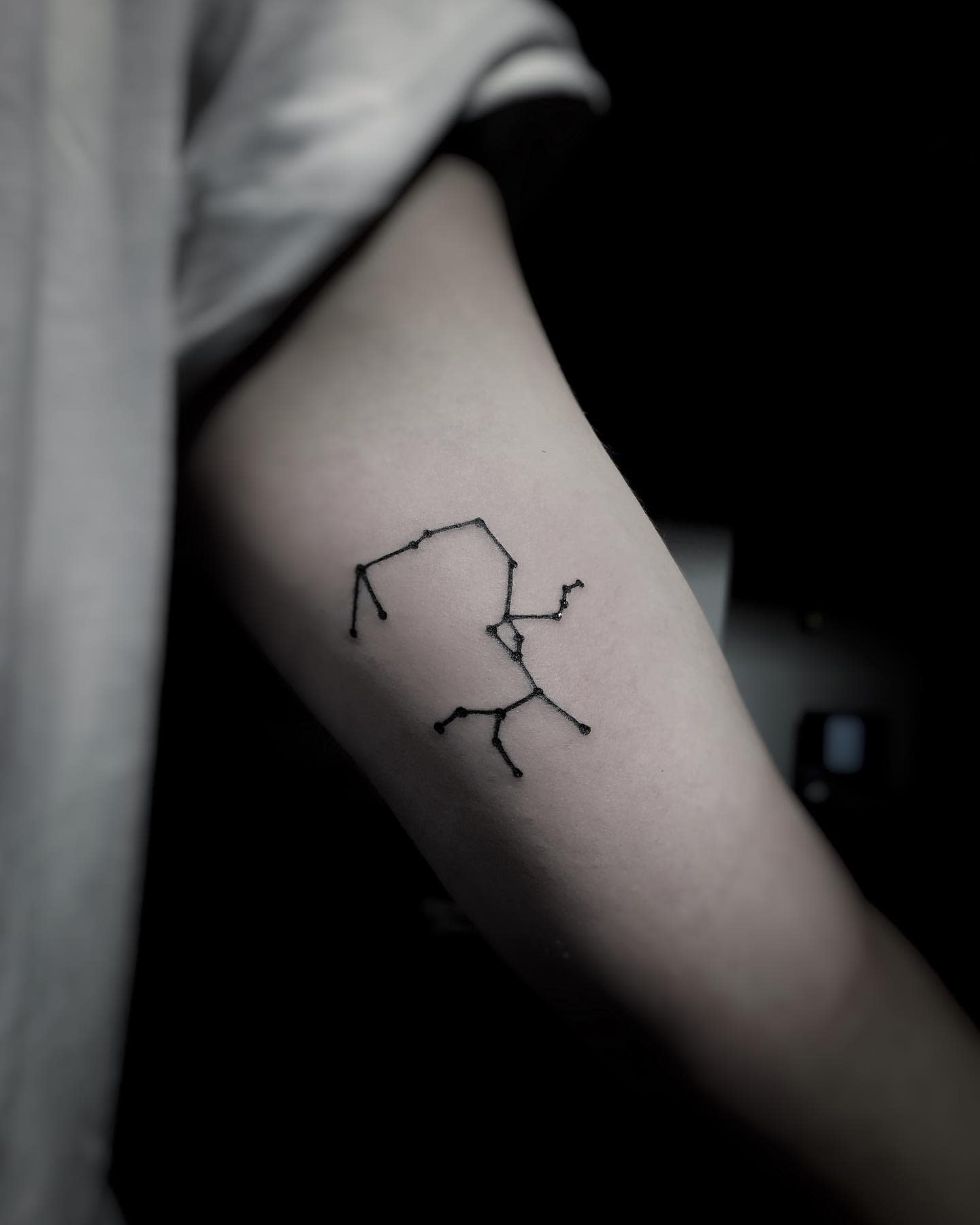 Tattoo of a Sagittarius constellation on an inner arm, in a black and white setting
