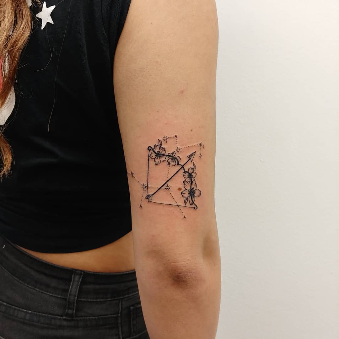 Geometric tattoo with floral accents on upper arm