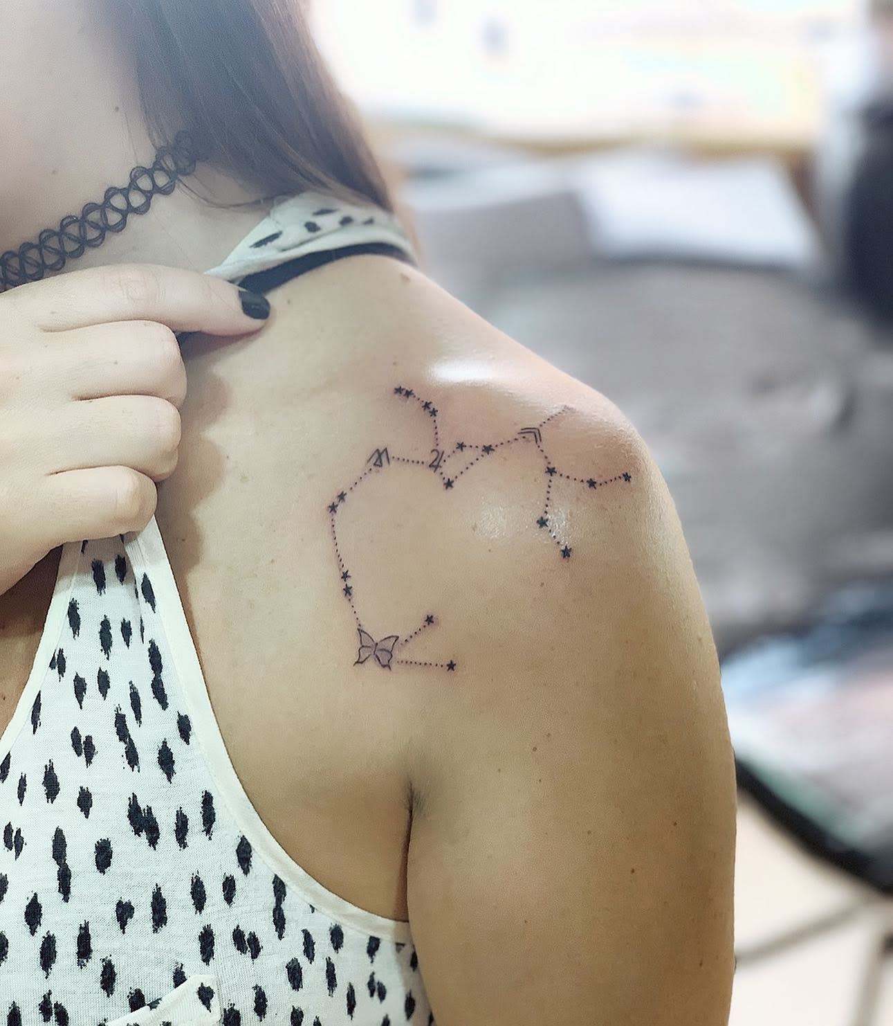 Close-up of a shoulder tattoo featuring a star constellation with a dotted line design