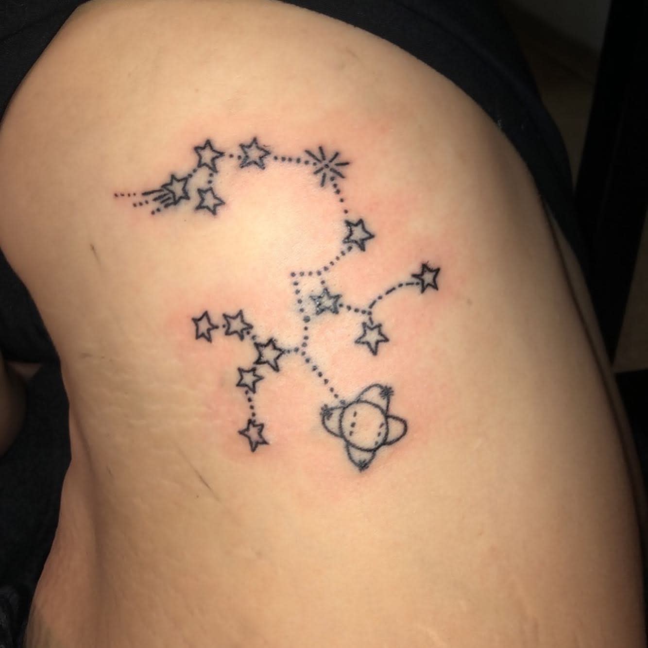 Tattoo of stars and a planet with dotted lines forming a constellation pattern