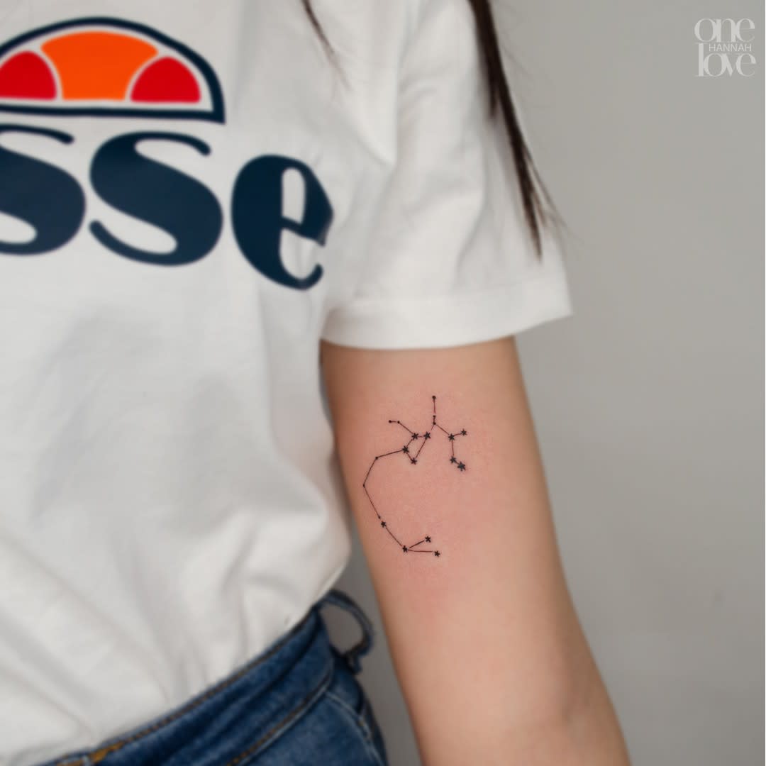 Tattoo of a Sagittarius constellation on the inside of an upper arm