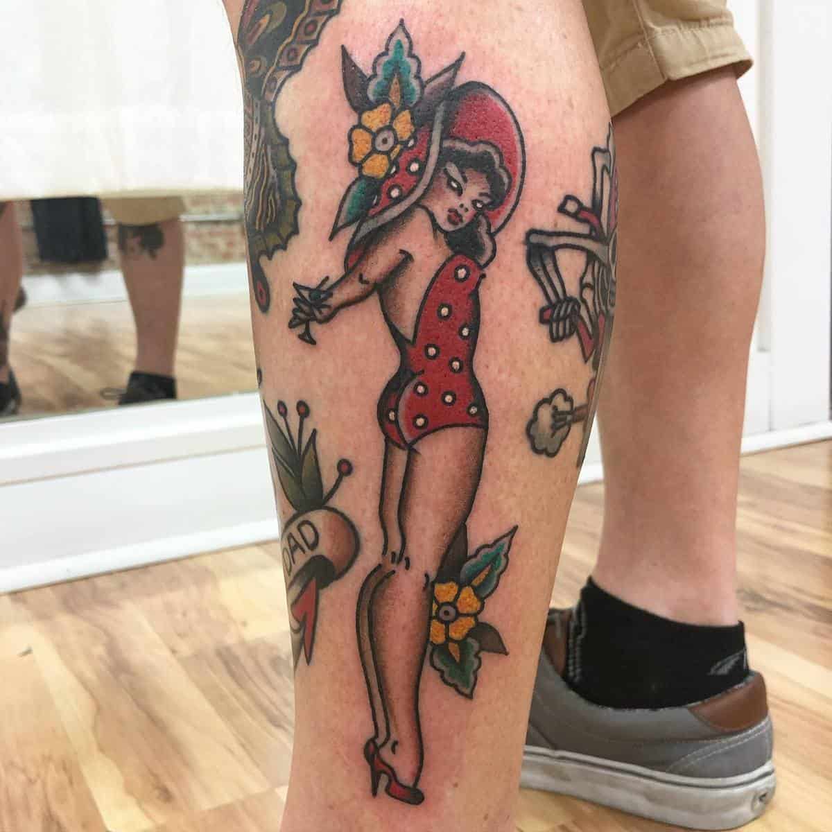 Tattoo of a woman in a red bathing suit and hat on someone's calf