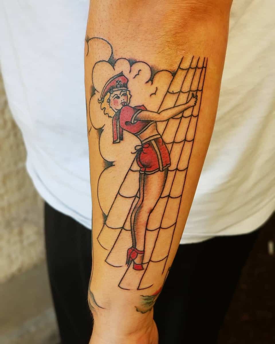 Forearm tattoo of a vintage pin-up style woman in sailor outfit climbing a rope ladder