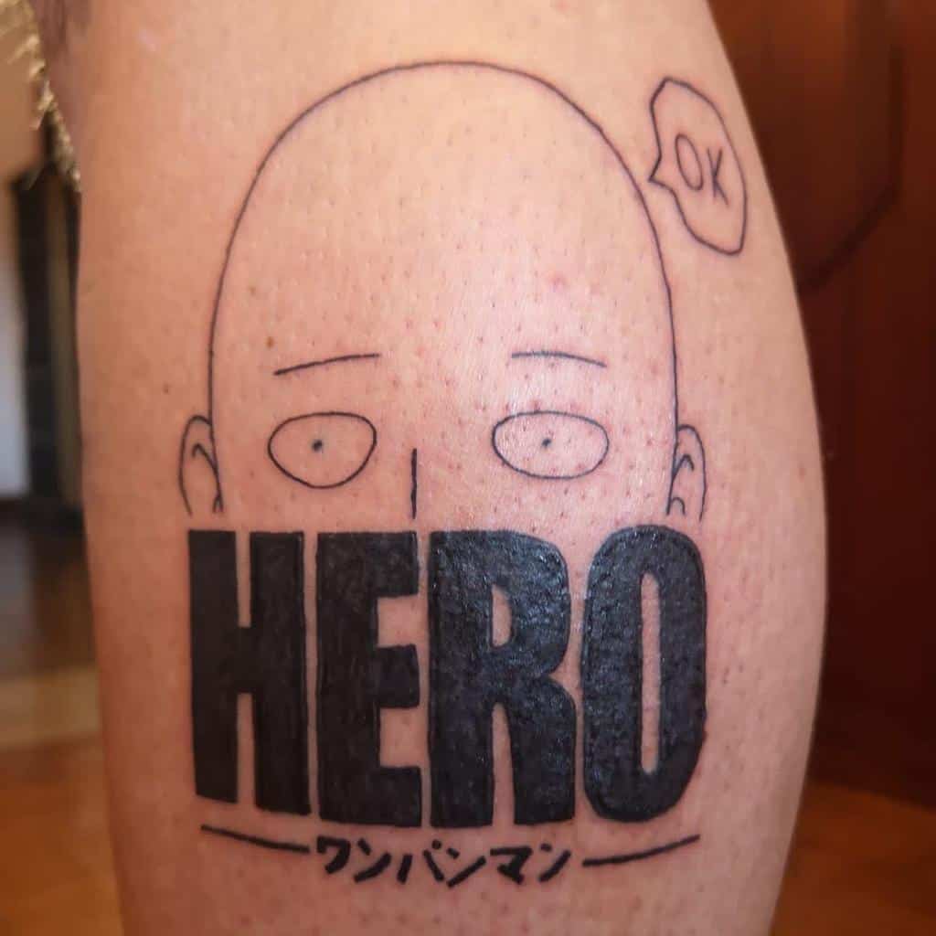 A minimalist tattoo of Saitama from One Punch Man, with his face peeking over the bold word "HERO" and a speech bubble saying "OK"