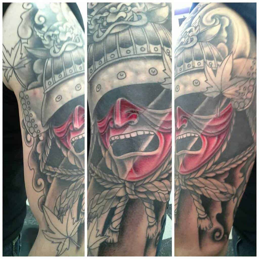 Dynamic samurai tattoo featuring a fierce red mask, traditional helmet, rope details, maple leaves, and swirling smoke accents